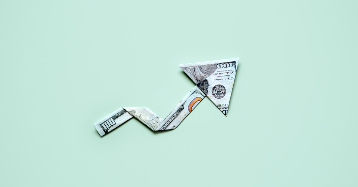dollar bill folded in an upward arrow representing healthcare cost increase