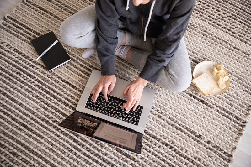 Person sitting on floor with laptop